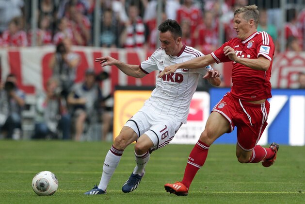 Nuremberg's Josip Drmic of Switzerland, left, and Bayern's Bastian Schweinsteiger challenge for the ball during the German first division Bundesliga soccer match between FC Bayern Munich and 1. FC Nuremberg, in Munich, southern Germany, Saturday, Aug. 24, 2013. (AP Photo/Matthias Schrader)
