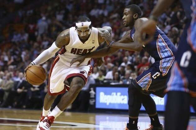 Miami Heat's LeBron James (6) drives around Charlotte Bobcats' Michael Kidd-Gilchrist (14) during the first half of an NBA basketball game in Miami, Monday, March 3, 2014. (AP Photo/J Pat Carter)
