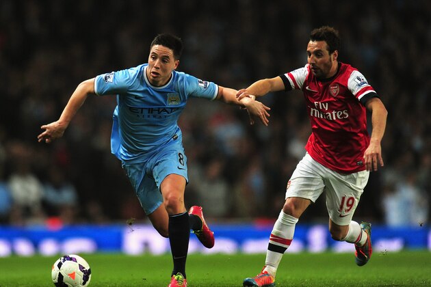 LONDON, ENGLAND - MARCH 29:  Samir Nasri of Manchester City and Santi Cazorla of Arsenal battle for the ball during the Barclays Premier League match between Arsenal and Manchester City at Emirates Stadium on March 29, 2014 in London, England.  (Photo by Shaun Botterill/Getty Images)