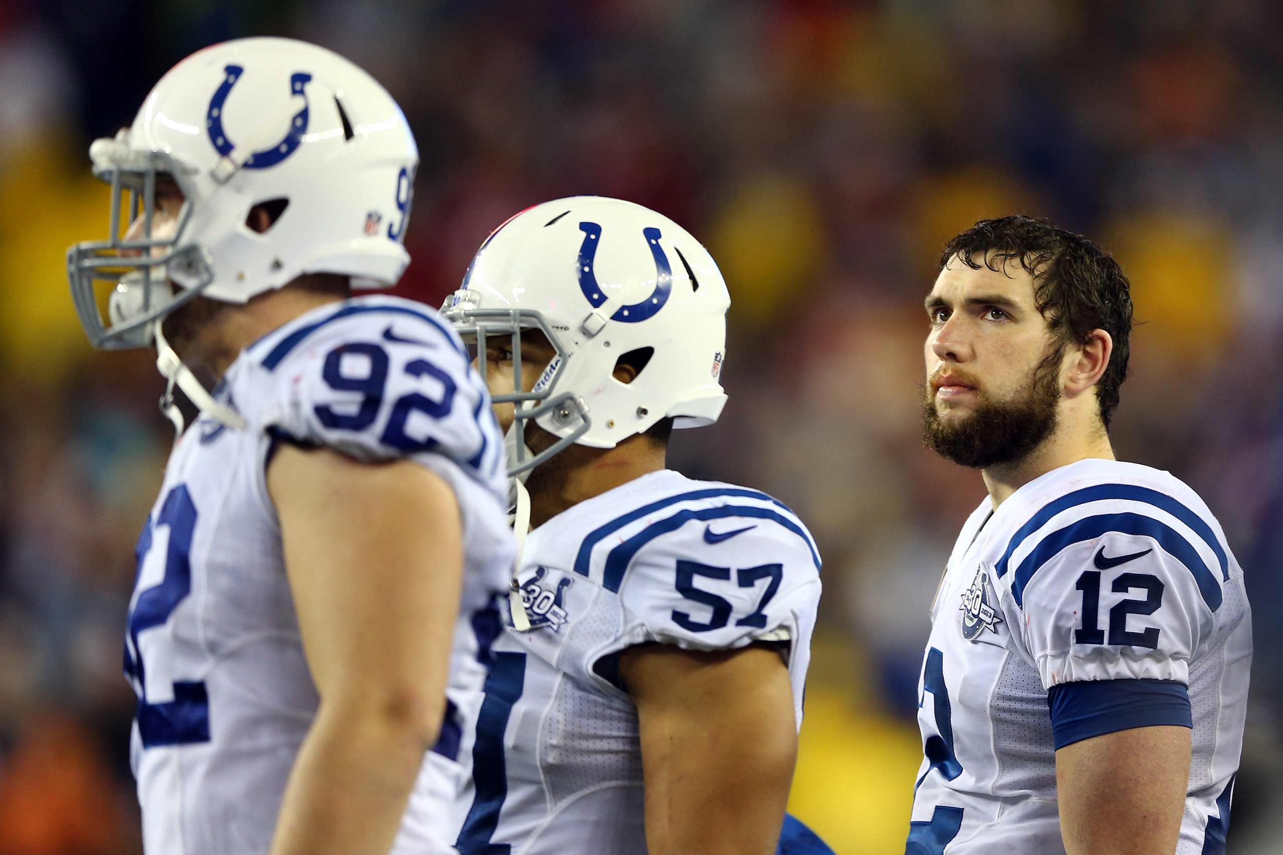 FOXBORO, MA - JANUARY 11:  Andrew Luck #12 of the Indianapolis Colts looks on from the sidelines against the New England Patriots during the AFC Divisional Playoff game at Gillette Stadium on January 11, 2014 in Foxboro, Massachusetts.  (Photo by Elsa/Getty Images)