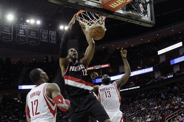 Portland Trail Blazers forward LaMarcus Aldridge (12) dunks between Houston Rocket's Dwight Howard (12) and James Harden (13) during the first half of an NBA basketball game, Monday, Jan. 20, 2014, in Houston. (AP Photo/Bob Levey)