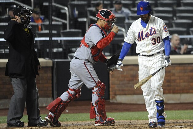 New York Mets right fielder Andrew Brown (30) strikes out for the final out as Washington Nationals catcher Jose Lobaton, center, heads to the mound in the ninth inning of a baseball game at Citi Field on Wednesday, April 2, 2014, in New York. The Nationals won 5-1. (AP Photo/Kathy Kmonicek)
