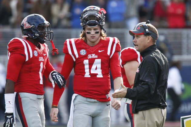 Mississippi football coach Hugh Freeze, right, confers with wide receiver Laquon Treadwell (1) and quarterback Bo Wallace (14) during a timeout in the second half of their NCAA college football game at Vaught-Hemingway Stadium in Oxford, Miss., on Saturday, Nov. 9, 2013. Mississippi won 34-24. (AP Photo/Rogelio V. Solis)