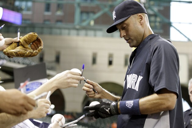 New York Yankees shortstop Derek Jeter signs autographs for fans before a baseball game against the Houston Astros, Wednesday, April 2, 2014, in Houston. (AP Photo/Patric Schneider)