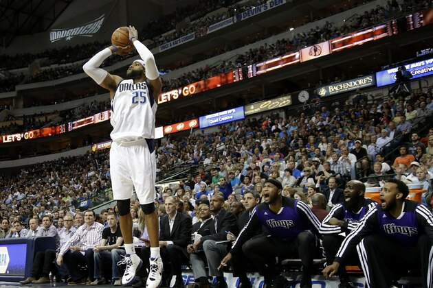 Dallas Mavericks' Vince Carter (25) goes up for a 3-point basket in front of the Sacramento Kings bench during an NBA basketball game, Saturday, March 29, 2014, in Dallas. (AP Photo/Tony Gutierrez)