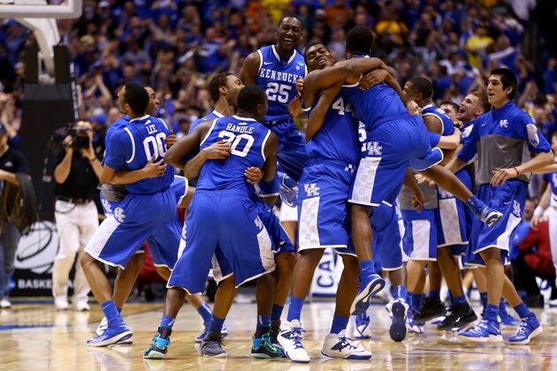 INDIANAPOLIS, IN - MARCH 30:  Aaron Harrison #2 of the Kentucky Wildcats celebrates with teammates Julius Randle #30 and Dakari Johnson #44 after defeating the Michigan Wolverines 75 to 72 in the midwest regional final of the 2014 NCAA Men's Basketball Tournament at Lucas Oil Stadium on March 30, 2014 in Indianapolis, Indiana.  (Photo by Andy Lyons/Getty Images)