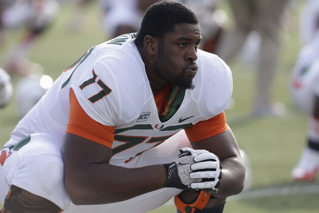 Miami's Seantrel Henderson (77) stretches during pre-game warmups prior to an NCAA college football game against Duke in Durham, N.C., Saturday, Nov. 16, 2013. (AP Photo/Gerry Broome)