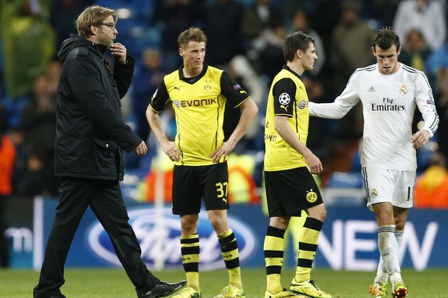 Dortmund head coach Juergen Klopp, left,  leaves the pitch after the Champions League quarterfinal first leg soccer match between Real Madrid and Borussia Dortmund at the Santiago Bernabeu   stadium in Madrid, Spain, Wednesday, April 2, 2014. (AP Photo/Andres Kudacki)