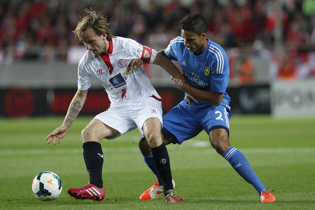 Real Madrid's Raphael Varane from France, right, and Sevilla's Ivan Rakitic from Croacia vie for the ball during their La Liga soccer match at the Ramon Sanchez Pizjuan stadium, in Seville, Spain on Wednesday, March 26, 2014. (AP Photo/Angel Fernandez)