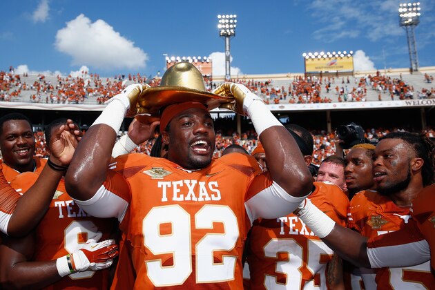 DALLAS, TX - OCTOBER 12:  Reggie Wilson #92 of the Texas Longhorns celebrates with the game trophy after the Longhorns beat the Sooners 36-20 at the Cotton Bowl on October 12, 2013 in Dallas, Texas.  (Photo by Tom Pennington/Getty Images)
