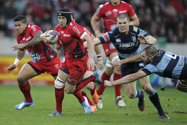 Toulon's Johann Van Niekerk keeps the ball in front of Cardiff's  Richard Smith, second from right and Chris Dicomidis, right, during their Heineken European Cup rugby match, in Nice, southeastern France, Satuday, Jan. 11, 2014. The winner of his pool 2 clash will qualify for the H Cup quarter final. (AP Photo/Lionel Cironneau)