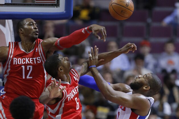 Houston Rockets center Dwight Howard (12) blocks a shot by Detroit Pistons center Greg Monroe, right, as Rockets forward Terrence Jones (6) helps defend the basket during the first half of an NBA basketball game Saturday, Dec. 21, 2013, in Auburn Hills, Mich. (AP Photo/Duane Burleson)