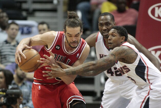 Chicago Bulls center Joakim Noah, left, and Atlanta Hawks guard Lou Williams, right front, scramble for a loose ball as Hawks' Elton Brand watches during the first half of an NBA basketball game Wednesday, April 2, 2014, in Atlanta. (AP Photo/Jason Getz)