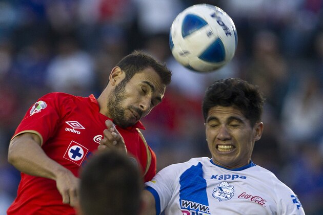 Cruz Azul's Alejandro Castro, left, heads the ball with Puebla's Uriel Alvarez at a Mexican soccer league match in Mexico City, Saturday, Feb.  15, 2014. (AP Photo/Christian Palma)