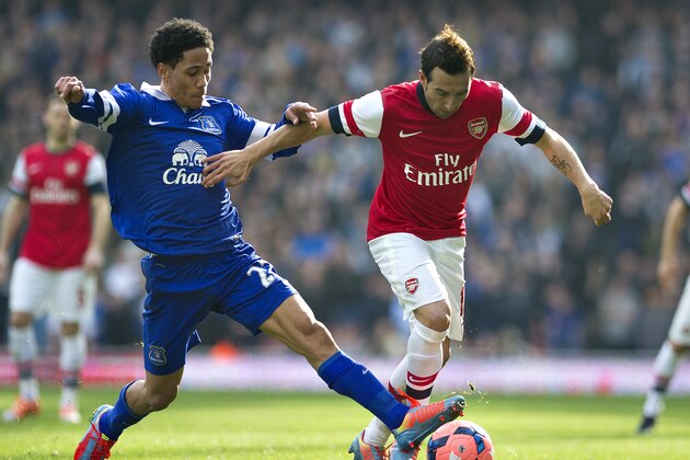 Arsenal's Santi Cazorla, right, fights for the ball with Everton's Steven Pienaar, during their FA Cup quarterfinal soccer match, at Emirates Stadium, in London, Saturday, March 8, 2014. (AP Photo/Bogdan Maran)