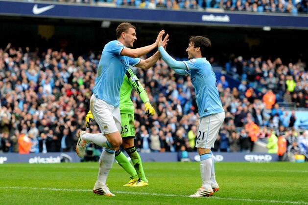 MANCHESTER, ENGLAND - APRIL 05:  Edin Dzeko of Manchester City is congratulated by teammate David Silva (R) after scoring his team's third goal past goalkeeper Paulo Gazzaniga of Southampton during the Barclays Premier League match between Manchester City and Southampton at Etihad Stadium on April 5, 2014 in Manchester, England.  (Photo by Chris Brunskill/Getty Images)