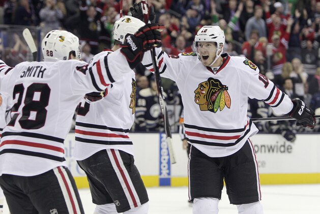 Chicago Blackhawks' Peter Regin, right, of Denmark, celebrates their goal against the Columbus Blue Jackets with teammates Ben Smith, left, and Bryan Bickell during the third period of an NHL hockey game on Friday, April 4, 2014, in Columbus, Ohio. The Blackhawks defeated the Blue Jackets 4-3. (AP Photo/Jay LaPrete)