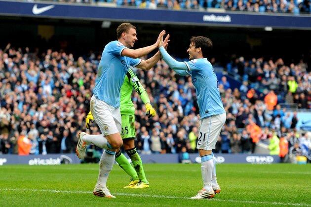 MANCHESTER, ENGLAND - APRIL 05:  Edin Dzeko of Manchester City is congratulated by teammate David Silva (R) after scoring his team's third goal past goalkeeper Paulo Gazzaniga of Southampton during the Barclays Premier League match between Manchester City and Southampton at Etihad Stadium on April 5, 2014 in Manchester, England.  (Photo by Chris Brunskill/Getty Images)