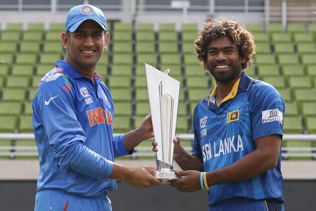 India's captain Mahendra Singh Dhoni, left, and Sri Lanka's captain Lasith Malinga pose with the winners trophy ahead of the ICC Twenty20 Cricket World Cup final match in Dhaka, Bangladesh, Saturday, April 5, 2014. (AP Photo/Aijaz Rahi)