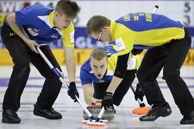 Sweden's Markus Eriksson, center, delivers the stone as teammates Christoffer Sundgren, left, and Kristian Lindstrom, right, sweep the path during a semi-final match against Canada at the 2014 World Men's Curling Championship held at the Capital Gymnasium in Beijing, China, Saturday, April 5, 2014. (AP Photo/Alexander F. Yuan)
