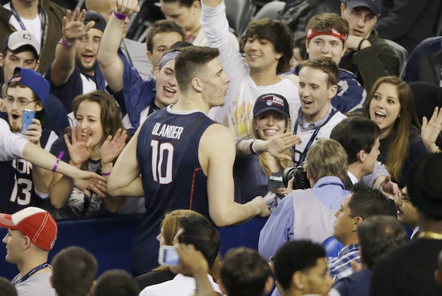 Connecticut fans celebrate with forward Tyler Olander after their team beat Florida 63-53 at their NCAA Final Four tournament college basketball semifinal game Saturday, April 5, 2014, in Arlington, Texas. (AP Photo/Tony Gutierrez)