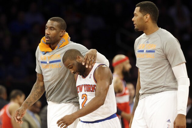 New York Knicks' Amar'e Stoudemire, left, and Jeremy Tyler, right, encourage Raymond Felton, center, during the second half of an NBA basketball game against the Washington Wizards Friday, April 4, 2014, in New York. The Wizards won the game 89-90. (AP Photo/Frank Franklin II)