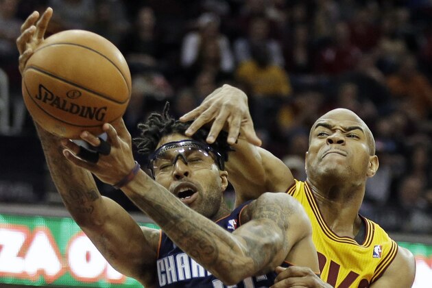 Cleveland Cavaliers' Jarrett Jack, right, fouls Charlotte Bobcats' Chris Douglas-Roberts (55) on a drive to the basket in the fourth quarter of an NBA basketball game on Saturday, April 5, 2014, in Cleveland. The Bobcats won 96-94 in overtime. (AP Photo/Mark Duncan)