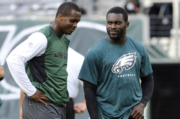 FILE - In this Aug. 29, 2013, file photo, New York Jets quarterback Geno Smith, left, talks to Philadelphia Eagles quarterback Michael Vick before a preseason NFL football game in East Rutherford, N.J. The Jets signed the former Philadelphia Eagles quarterback to a one-year deal Friday, March 21, 2014, and released Mark Sanchez, the one-time face of the franchise.   (AP Photo/Bill Kostroun, File)