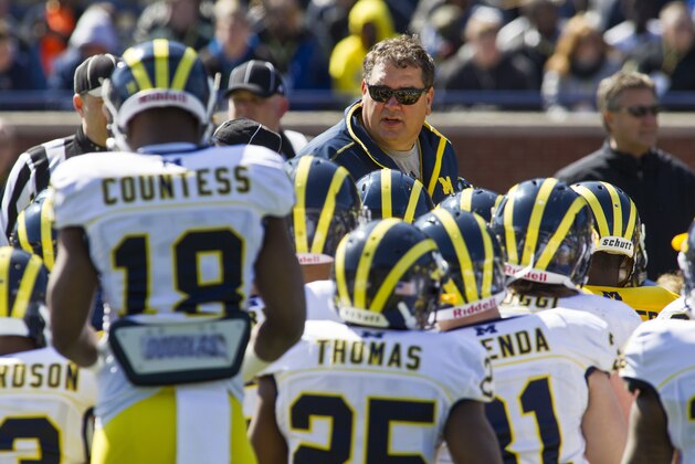 Michigan head coach Brady Hoke, center top, addresses his players gathered around him during the football team's annual spring game, Saturday, April 5, 2014, in Ann Arbor, Mich. (AP Photo/Tony Ding)