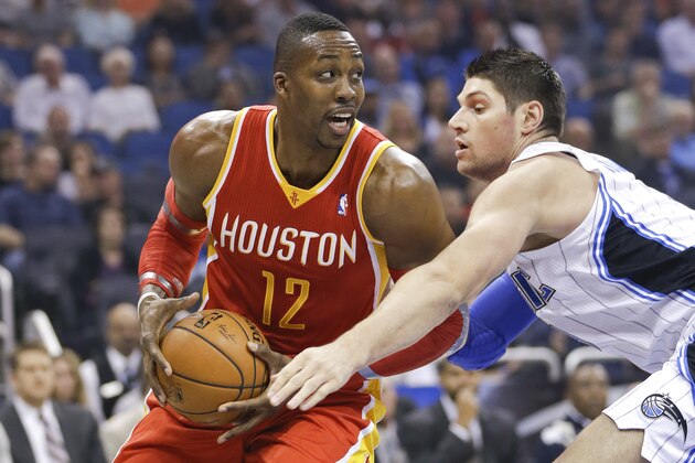 Houston Rockets' Dwight Howard (12) looks for a way around Orlando Magic's Nikola Vucevic during the first half of an NBA basketball game in Orlando, Fla., Wednesday, March 5, 2014. (AP Photo/John Raoux)