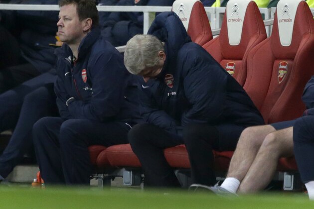 Arsenal's French manager Arsene Wenger, center, looks down during the English Premier League soccer match between Arsenal and Swansea City at the Emirates Stadium in London, Tuesday, March 25, 2014.  (AP Photo/Matt Dunham)