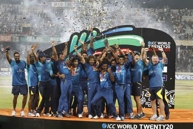 Sri Lanka’s players and team officials pose for a group photo while celebrating with the  trophy after winning the ICC Twenty20 Cricket World Cup in Dhaka, Bangladesh, Sunday, April 6, 2014. Sri Lanka won the title defeating India by six wickets. (AP Photo/A.M. Ahad)