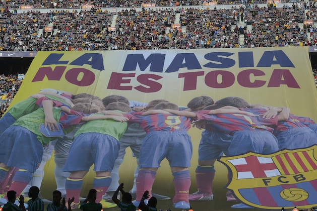 FC Barcelona's supporters unveil a giant banner reading in Catalan 'La Masia, don't touch it' prior to the Spanish La Liga soccer match between FC Barcelona and Betis at the Camp Nou stadium in Barcelona, Spain, Saturday, April 5, 2014. Barcelona has been