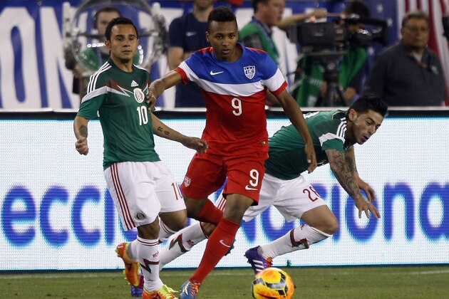 U.S. Julian Green (9) battles for the ball with Mexico defenders during the second half of an international friendly soccer match Wednesday, April 2, 2014, in Glendale, Ariz. The game ended in a 2-2 draw. (AP Photo/Rock Scuteri)