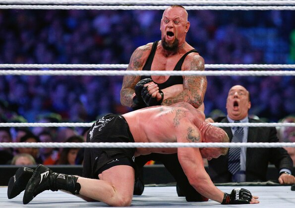 IMAGE DISTRIBUTED FOR WWE - The Undertaker, top, and Brock Lesnar wrestle during Wrestlemania XXX at the Mercedes-Benz Super Dome in New Orleans on Sunday, April 6, 2014. (Jonathan Bachman/AP Images for WWE)