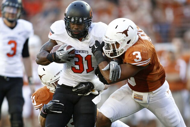 AUSTIN, TX - OCTOBER 15:  Running back Jeremy Smith #31 of the Oklahoma State University Cowboys drags along safety Blake Gideon #21 and linebacker Jordan Hicks #3 of the Texas Longhorns in the fourth quarter on October 15, 2011 at Darrell K. Royal-Texas Memorial Stadium in Austin, Texas.  Oklahoma State beat Texas 38-26. (Photo by Erich Schlegel/Getty Images)