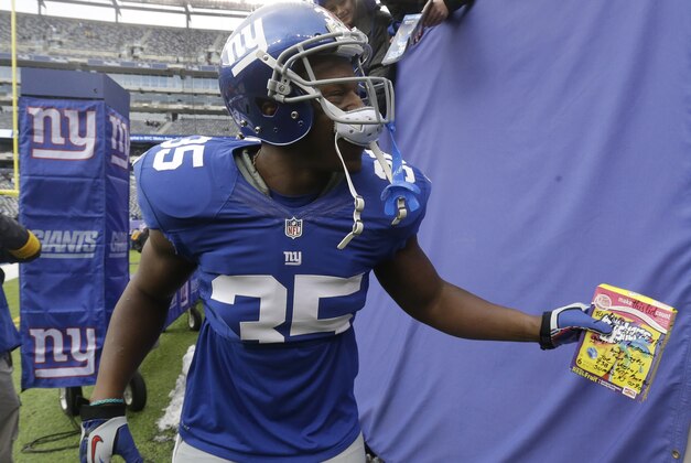 New York Giants running back Andre Brown holds a gift from Joe Vostal, of Summit, N.J., which was given to him for his birthday before an NFL football game against the Seattle Seahawks, Sunday, Dec. 15, 2013, in East Rutherford, N.J. Brown turned 27 on Sunday. (AP Photo/Julio Cortez)