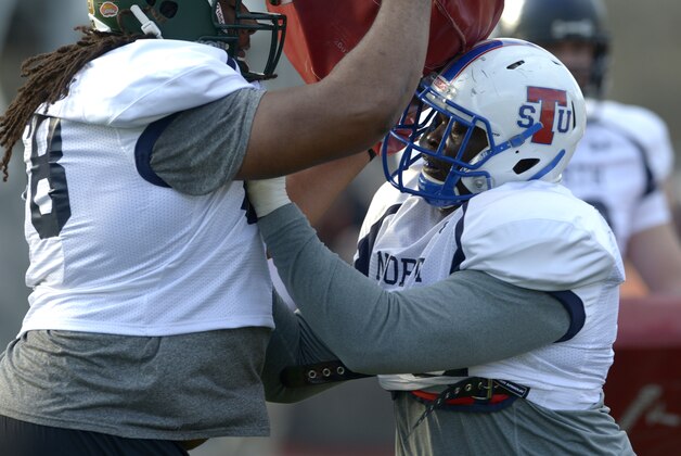 North Squad offensive guard Cyril Richardson of Baylor (68), left, holds a blocking dummy as offensive guard Kadeem Edwards of Tennessee State (79) blocks him during Senior Bowl practice at Ladd-Peebles Stadium, Monday, Jan. 20, 2014,  in Mobile, Ala.  (AP Photo/G.M. Andrews)