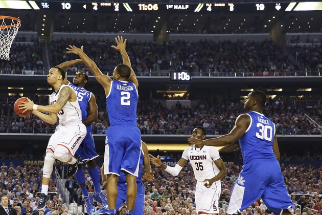 Connecticut guard Shabazz Napier shoots between Kentucky guard Dominique Hawkins (25) and guard Aaron Harrison (2) during the first half of the NCAA Final Four tournament college basketball championship game Monday, April 7, 2014, in Arlington, Texas. (AP Photo/David J. Phillip)