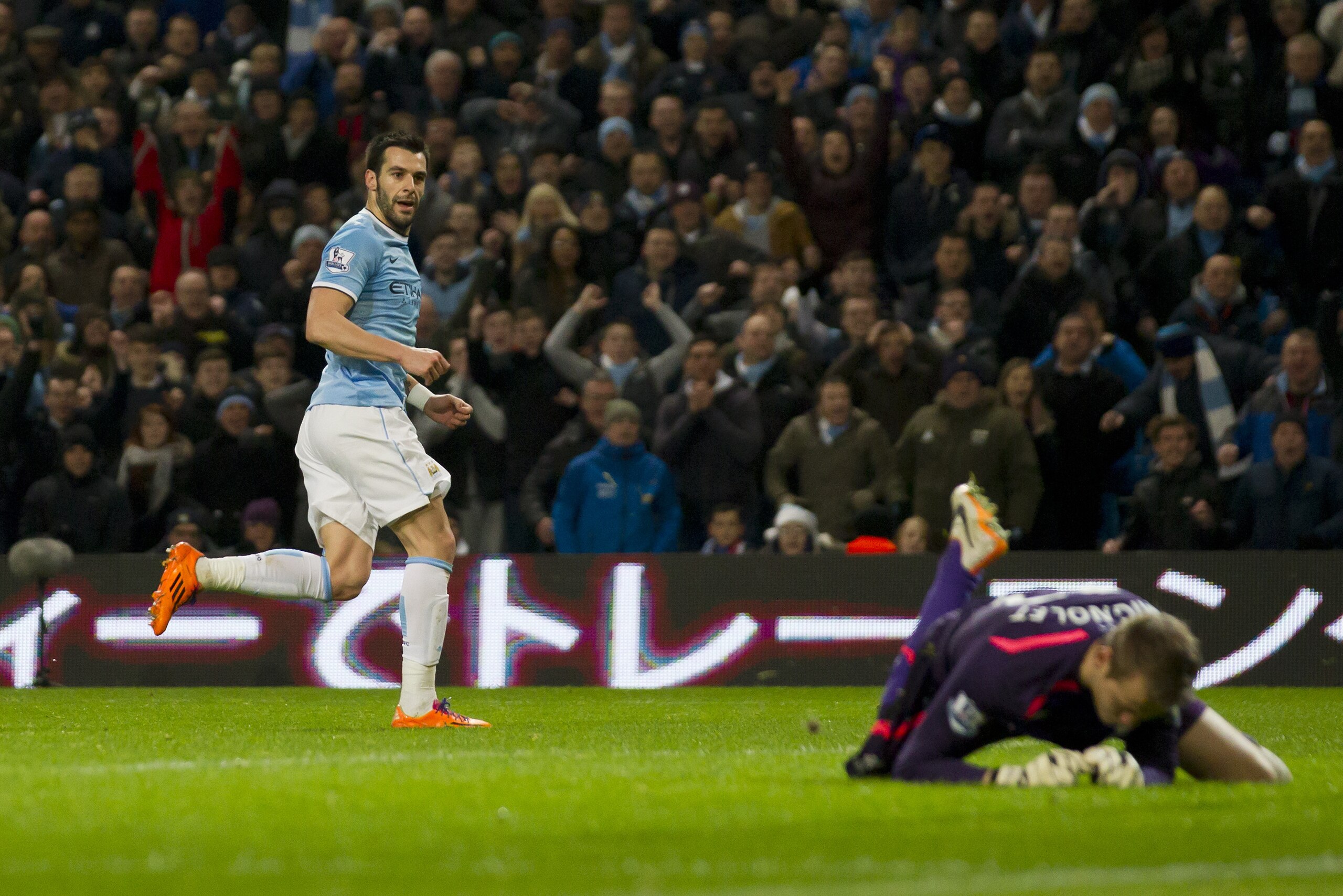 Manchester City's Alvaro Negredo, left, turns to celebrate after scoring past Liverpool's goalkeeper Simon Mignolet during their English Premier League soccer match at the Etihad Stadium, Manchester, England, Thursday Dec. 26, 2013. (AP Photo/Jon Super)
