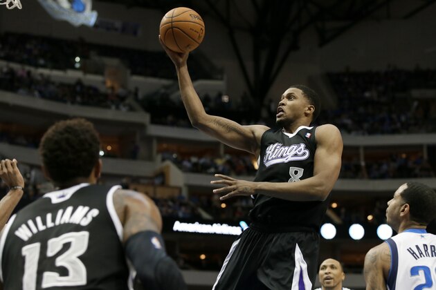 Sacramento Kings' Derrick Williams (13) and Dallas Mavericks' Devin Harris, right, watch as the Kings' Rudy Gay (8) breaks to the basket for a shot in the first half of an NBA basketball game, Saturday, March 29, 2014, in Dallas. (AP Photo/Tony Gutierrez)