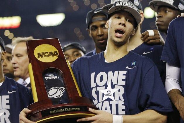 Connecticut guard Shabazz Napier holds the championship trophy after defeating Kentucky 60-54, at the NCAA Final Four tournament college basketball championship game Monday, April 7, 2014, in Arlington, Texas. (AP Photo/David J. Phillip)