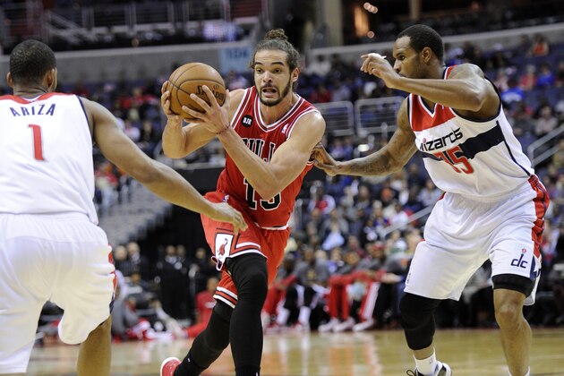 Chicago Bulls center Joakim Noah, center, drives to the basket against Washington Wizards' Trevor Ariza (1) and Trevor Booker (35) during the first half of an NBA basketball game, Saturday, April 5, 2014, in Washington. (AP Photo/Nick Wass)