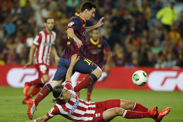 Barcelona's Lionel Messi from Argentina in action with Atletico de Madrid's Filipe Luis, from Brazil,  during a Spain Super Cup soccer match at the Camp nou stadium in Barcelona, Spain, Wednesday, Aug. 28, 2013. (AP Photo/Emilio Morenatti)