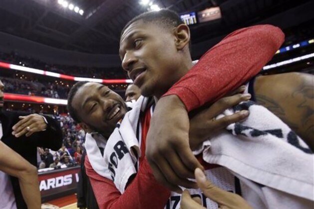 Washington Wizards guards John Wall, left, and Bradley Beal celebrate after an NBA basketball game against the Boston Celtics on Wednesday, April 2, 2014, in Washington. The Wizards won 118-92, and clinched a playoff berth. (AP Photo/Alex Brandon)