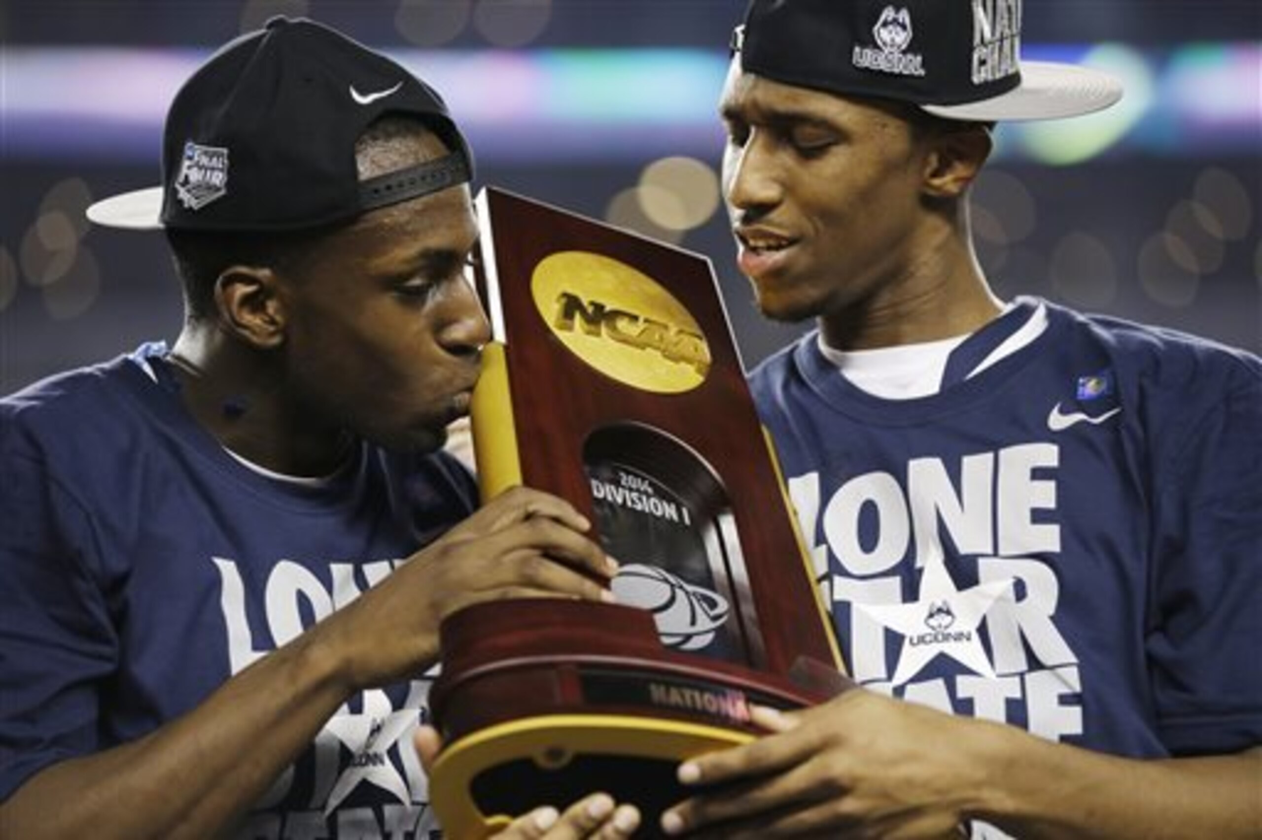 CORRECTS BOATRIGHT TO LASAN KROMAH- Connecticut guard Terrence Samuel, left, and guard Lasan Kromah  hold the championship trophy after beating Kentucky 60-54, at the NCAA Final Four tournament college basketball championship game Monday, April 7, 2014, in Arlington, Texas. (AP Photo/David J. Phillip)