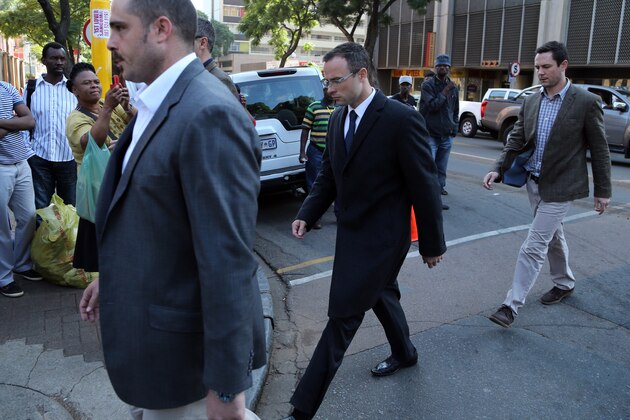 Oscar Pistorius, middle, with unidentified relatives walks towards the high court in Pretoria, South Africa, Tuesday, April 8, 2014. Pistorius is charged with murder for the shooting death of his girlfriend, Reeva Steenkamp, on Valentines Day in 2013. (AP Photo/Themba Hadebe)