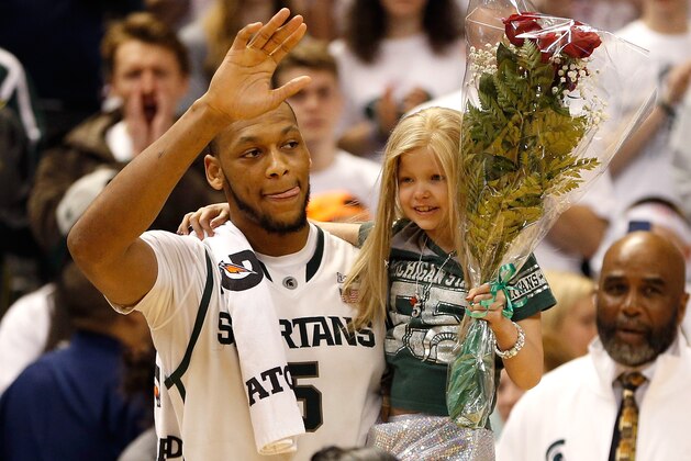 EAST LANSING, MI - FEBRUARY 06:  Adreian Payne #5 of the Michigan State Spartans walks on the floor for Senior night with Lacey Holsworth, a 8-year-old from St. Johns Michigan who is battling cancer, after defeating the Iowa Hawkeyes 86-76 at the Jack T. Breslin Student Events Center on February 6, 2014 in East Lansing, Michigan. (Photo by Gregory Shamus/Getty Images)