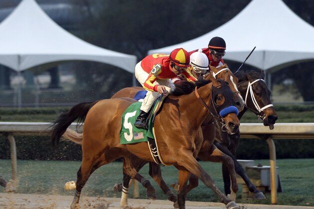 Hoppertunity and jockey Mike Smith (5) leads Tapiture and jockey Ricardo Santana Jr., center,  and Ride On Curlin and jockey Kent Desormeaux, right, to the win the the $600,000 Rebel Stakes horse race at Oaklawn Park in Hot Springs, Ark., Saturday, March 15, 2014. (AP Photo/Danny Johnston)