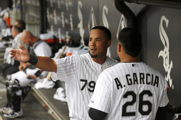 Chicago White Sox first baseman Jose Abreu left, talks to Avisail Garcia in the dugout during an Opening Day baseball game against the Minnesota Twins Monday, March 31, 2014, in Chicago. (AP Photo/Charles Rex Arbogast)